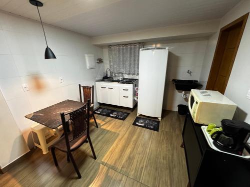 una piccola cucina con tavolo e frigorifero di Vivaê Studio a Vila Velha