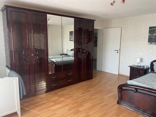 een slaapkamer met een grote houten kast met een spiegel bij Sunshine FeWo in Rust