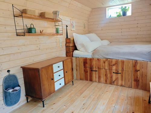 a bedroom with a bed and a desk in a cabin at Tiny House am Wald in Heideblick