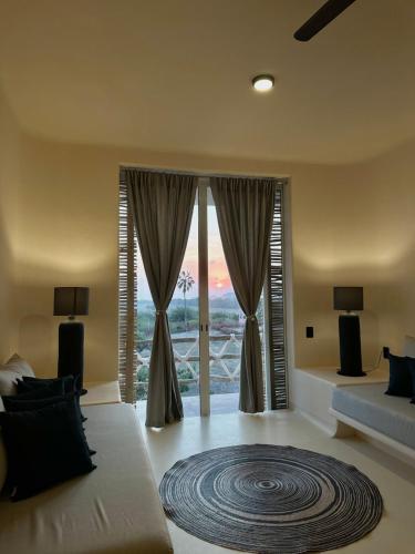 a living room with a large window with a view at Chamela Boutique Apartments in Chamela