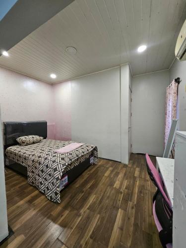a bedroom with a bed and a wooden floor at Witte Huis Cirendeu in Cipayung Tiga