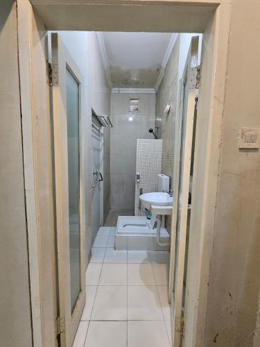 a bathroom with a sink and a shower and a toilet at Witte Huis Cirendeu in Cipayung Tiga