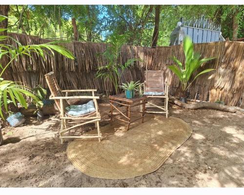 twee stoelen en een tafel voor een hek bij Seaside studio Kilifi in Kilifi