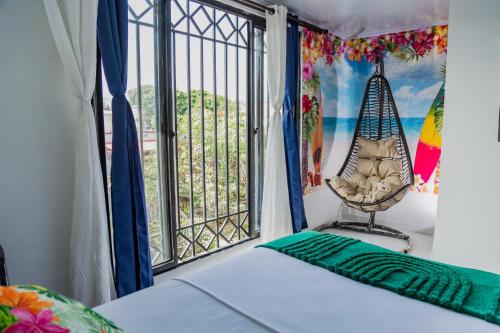 a room with a bed and a window with a swing at Coliving7 Aparta Hotel & Habitaciones in Ibagué