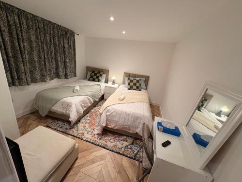 a small bedroom with two beds and a mirror at Cozy living in Great Barr Birmingham in Holly Lane