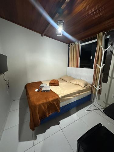 a bedroom with a bed with a blanket on it at Hospedagem do Centro in Arraial do Cabo
