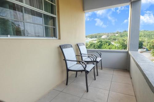 2 stoelen op een balkon met uitzicht bij Modern Cozy Apartment in Buckleys