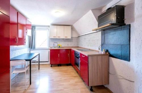 een kleine keuken met rode kasten en een tafel bij Nest-Unterkunft in Bad Überkingen