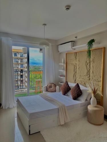 a bedroom with a large bed and a large window at Maison kh in Suba