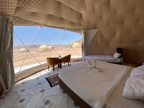 een slaapkamer met een bed en uitzicht op de woestijn bij Princess luxury camp in Wadi Rum