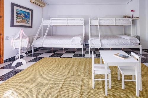 a room with two bunk beds and a table at Finca Aquí Me Quedo in Murcia