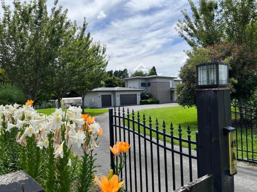 a black fence with orange and white flowers at Tamahere Lifestyle in Tamahere