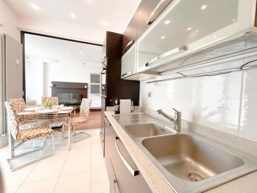 a kitchen with a sink and a dining table at Elegante appartamento - Aeroporto - Porto - WiFi - Casa Gelsomino in Genoa
