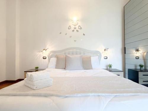 a white bed with white sheets and pillows on it at Elegante appartamento - Aeroporto - Porto - WiFi - Casa Gelsomino in Genoa