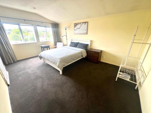 a bedroom with a bed and a ladder in it at Cosy Retreat Near Mairangi Bay in Auckland
