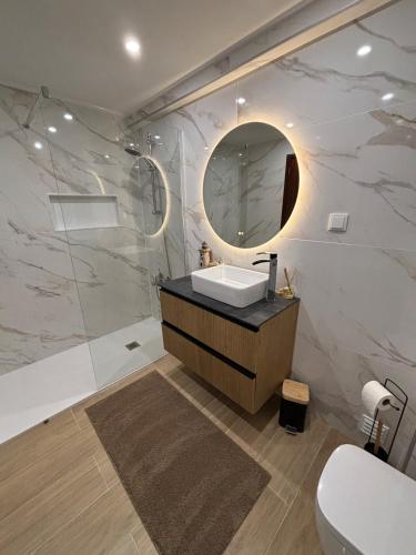 a bathroom with a sink and a mirror at Apartamento - The Light House in Peniche