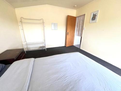 a bedroom with a large bed and a window at Cosy Retreat Near Mairangi Bay in Auckland