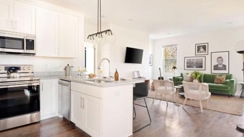 a kitchen and living room with white cabinets and a couch at Hart Suite 9 by AvantStay Gorgeous Town House w Modern Amenities in Nashville in Nashville