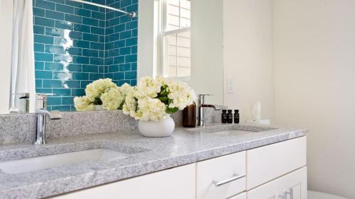 a bathroom with two sinks and a vase of flowers at Hart Suite 9 by AvantStay Gorgeous Town House w Modern Amenities in Nashville in Nashville