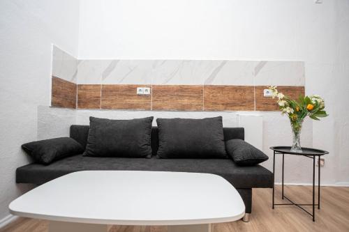 un soggiorno con un divano e un vaso di fiori di Easy Flexhome Hostel a Berlino