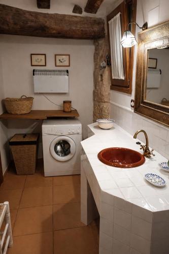 a bathroom with a sink and a washing machine at Ca l'Era in Horta de San Joan