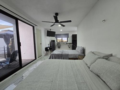 una camera da letto con un letto e un ventilatore a soffitto di Loft2 PB a Mérida