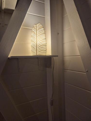 een lamp in een kast met een plank waarop een surfplank staat bij "Fleur d'Hibiscus" Maison de charme au calme à Marie-Galante in Saint-Louis