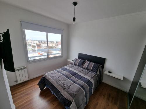 a bedroom with a bed and a large window at Premium apartment San Luis Centro in San Luis