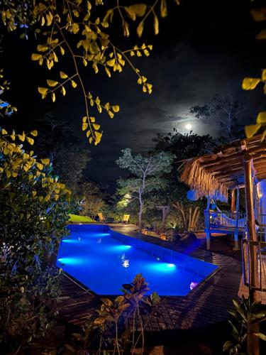 een zwembad dat 's nachts verlicht is bij Casa Vento Curimãs in Barroquinha