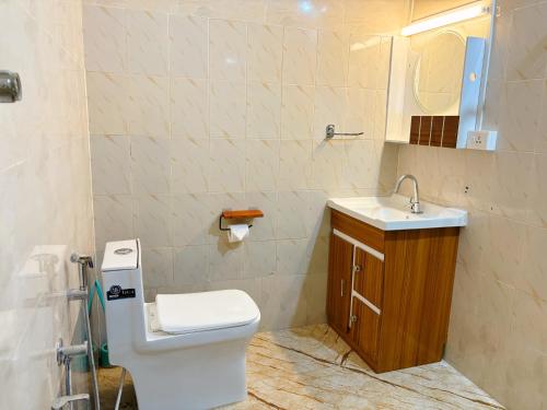 a bathroom with a toilet and a sink and a mirror at Saralalayam in Varkala
