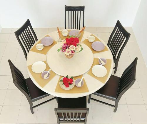 einen Esstisch mit Stühlen und eine Schüssel Blumen in der Unterkunft 涵舍homestay in Sibu