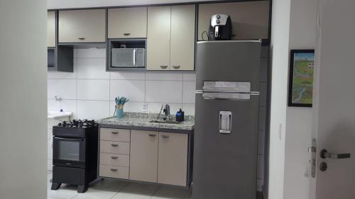 une cuisine avec des armoires blanches et un réfrigérateur noir dans l'établissement Céu da Mantiqueira, à Extrema