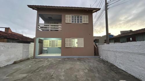 una piccola casa con una recinzione di fronte di Microcasa Nascimento a Imbituba