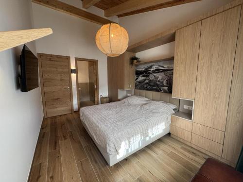 une chambre avec un lit et un lustre dans l'établissement Birdie Lodge, à Sankt Lambrecht