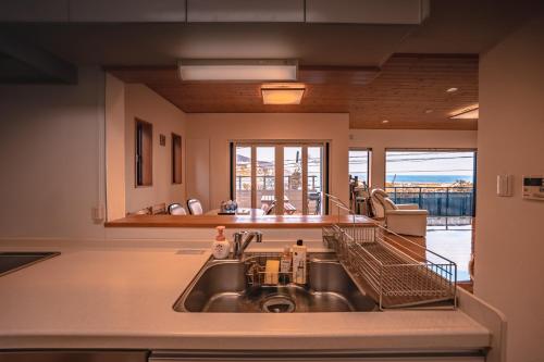a kitchen with a sink and a large window at さざなみハウス熱海 in Atami