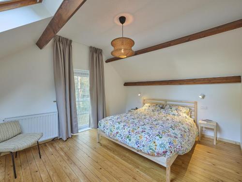 a bedroom with a bed and a couch and a window at Lierelodge in Oud-Turnhout