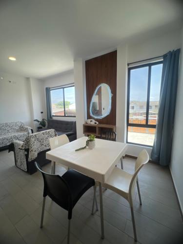 un soggiorno con tavolo e sedie bianchi di Suite Miramar 4 vista lateral al mar a Playas