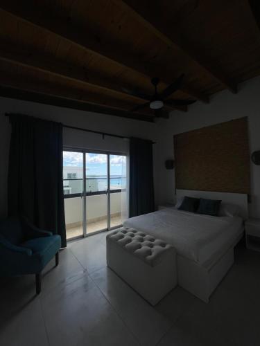 een slaapkamer met een bed, een bank en een raam bij Boca Chica Luxury apartment in Boca Chica