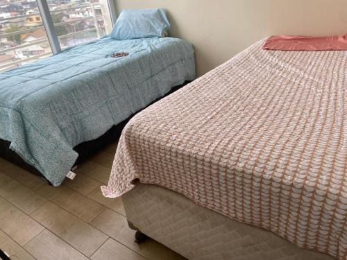 a bedroom with two beds and a window at Dpto 2 dormitorios vista al mar in Concón