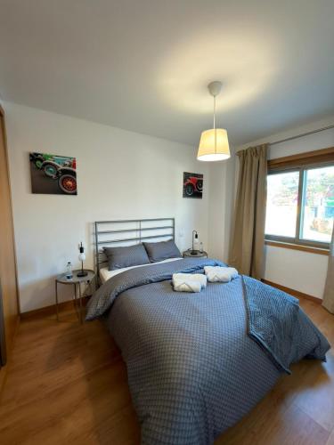 a bedroom with a bed with two towels on it at Alojamento Local Pando in Vila do Conde