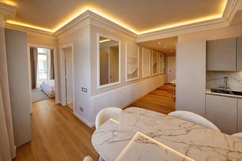 una cucina e una sala da pranzo con tavolo e sedie in marmo di Royal Suite Apartment a Trieste