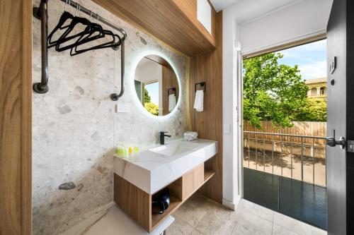 a bathroom with a sink and a mirror at Kingsway Motel Geelong in Geelong
