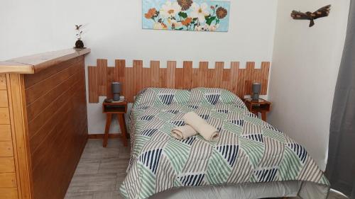 a bedroom with a bed with a striped comforter at Los Nenúfares in Lago Puelo