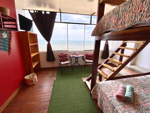 a bedroom with a bunk bed and a table with a view at Surf House Chicama in Puerto Chicama