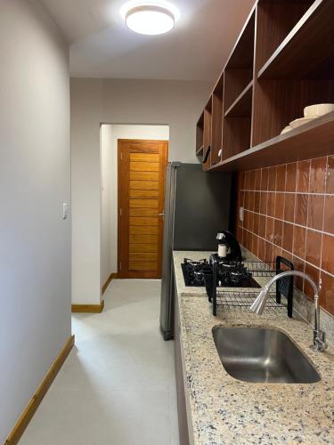 a kitchen with a sink and a stove at Sol de Marau - Taipu de Fora - próximo das piscinas naturais in Marau
