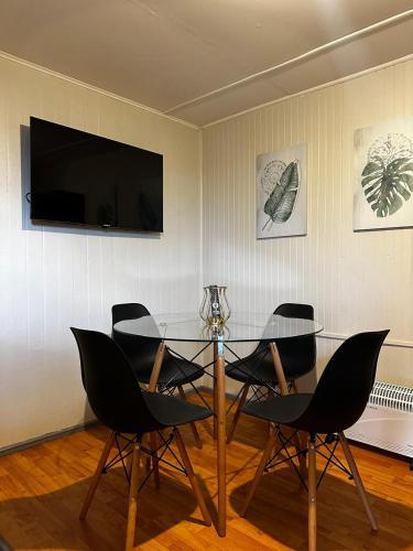 een eetkamer met een glazen tafel en stoelen bij COMODA Y HERMOSA CABAÑA DE 2 dormitorios in Temuco