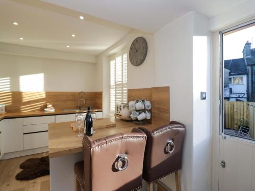 een keuken met een tafel en een klok aan de muur bij Park View in Ambleside