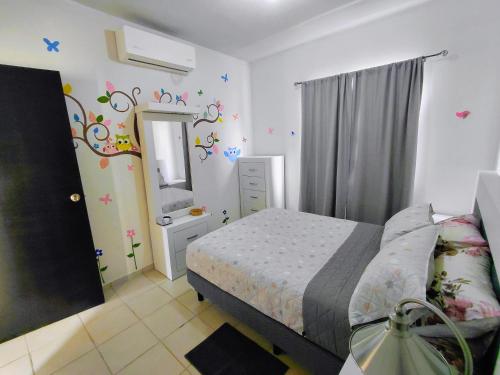 a small bedroom with a bed and a mirror at Residencia Mediterráneo con Casa Club y Alberca in La Paz
