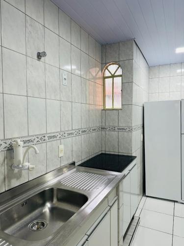a kitchen with a sink and a refrigerator at Apartamento 4 quartos Contagem in Contagem