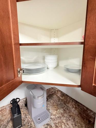 een kast met borden en kommen op een plank bij True Haven Deluxe in Prince George